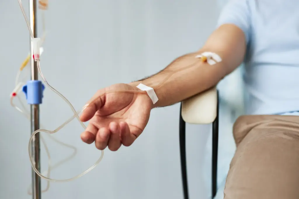 Patient receiving NAD IV therapy with intravenous drip connected to arm in a clinical setting.